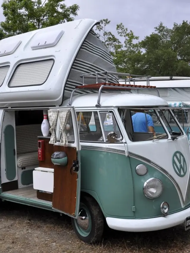 Combi Volkswagen bleu avec toit ouvert avec d'autres combis derrière