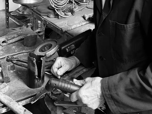 Artiste dans son atelier de sculptures avec outil (photo en noir et blanc)
