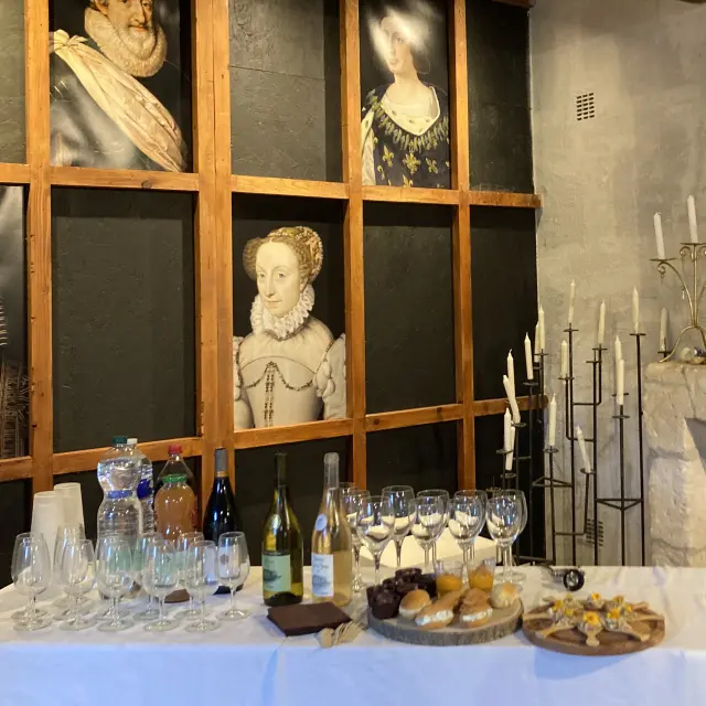 Table avec vin et mets devant des portraits anciens