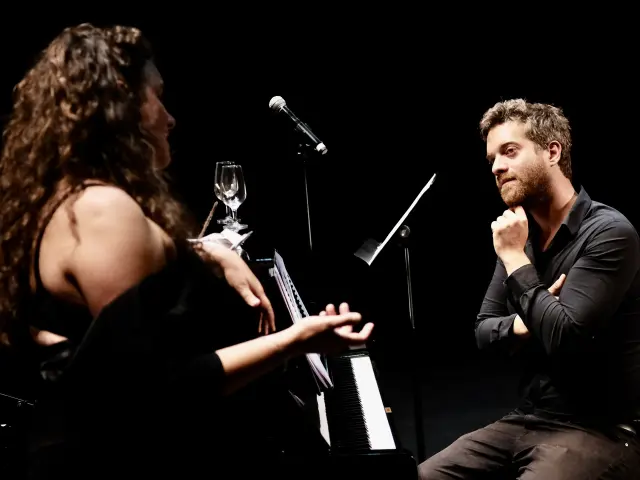 Sur fond noir, une femme chante, un homme assit au piano se regardent